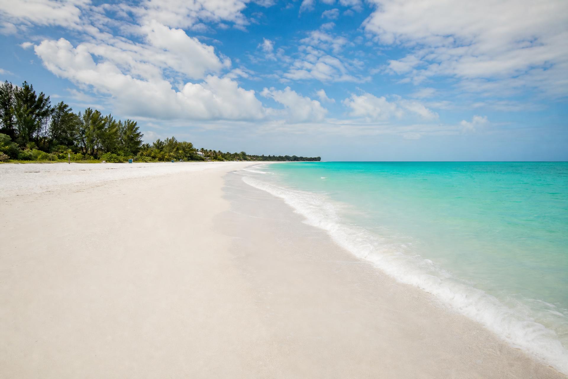Pristine white sand beach with turquoise waves on Anna Maria Island